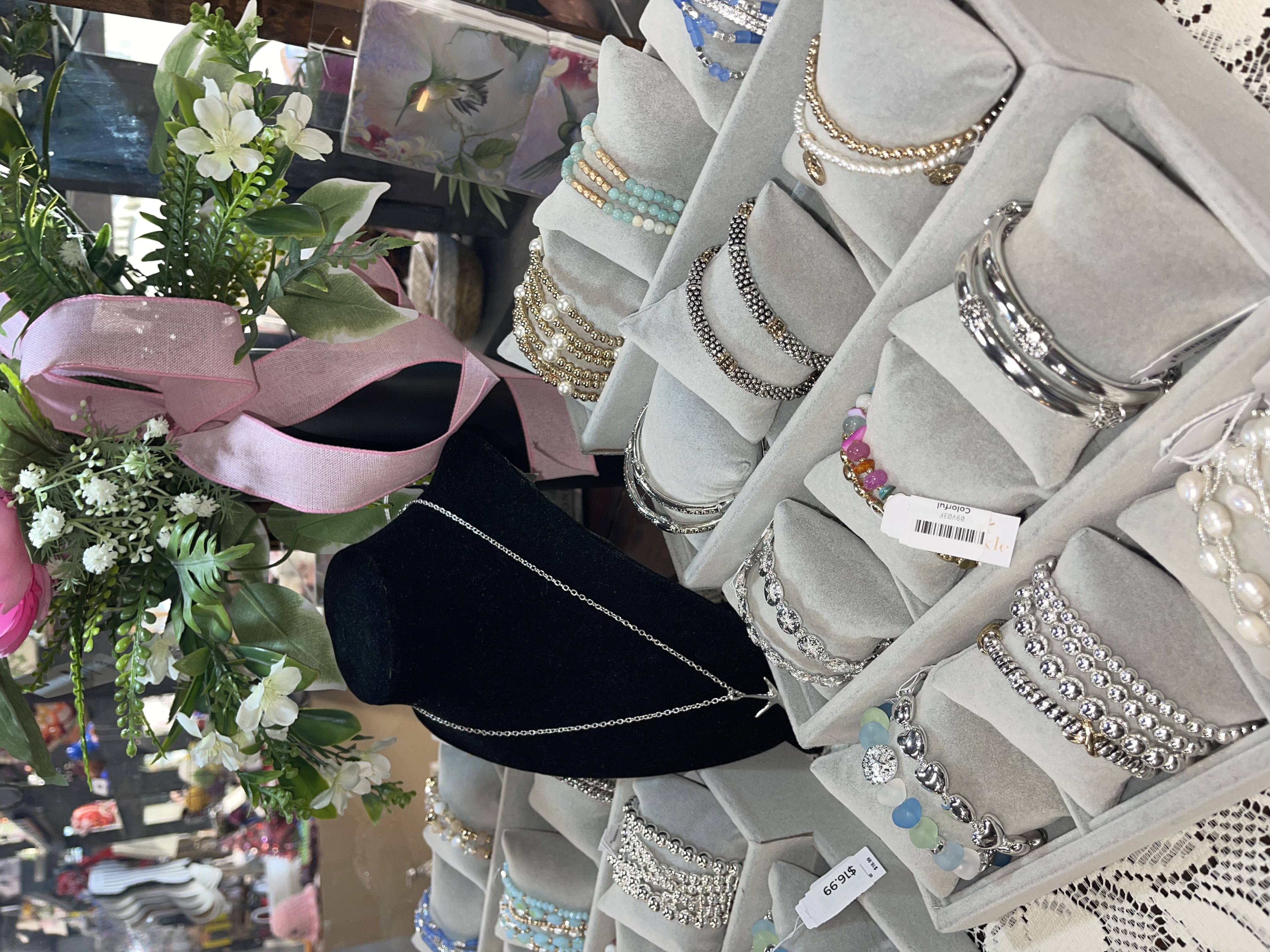 Curated vintage home decor setup with a wooden desk, gold accents, vases, a reading figurine, and layered art in a cozy booth setting.