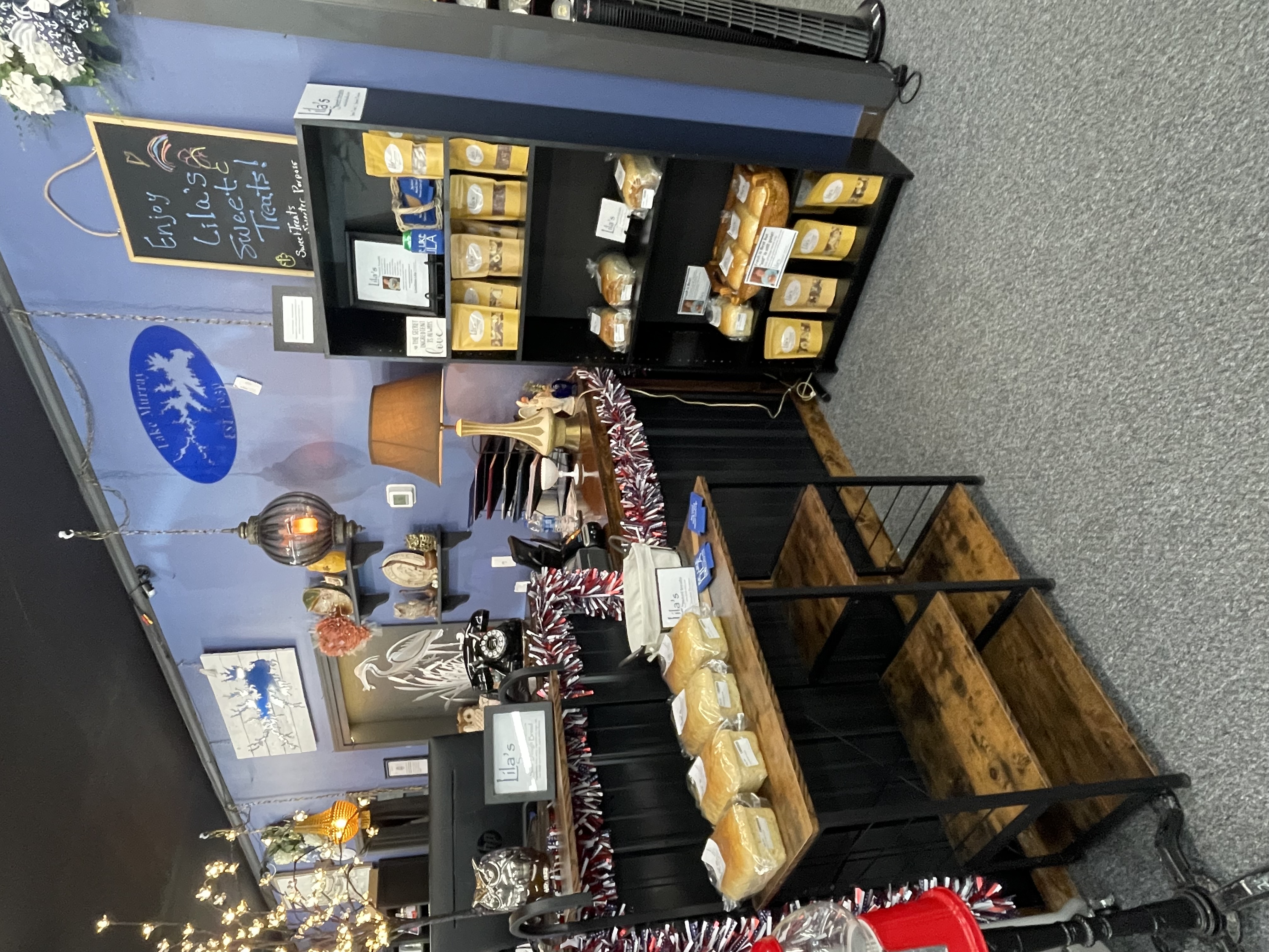 Vendor booth filled with vintage home decor, furniture, and accessories, including lamps, artwork, and dishes.