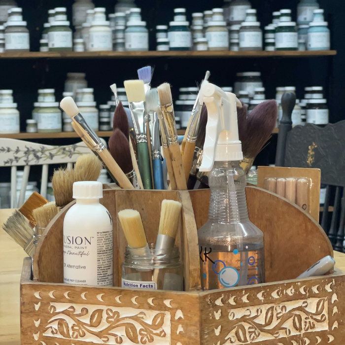 Smiling participants holding finished wreaths after a DIY class.