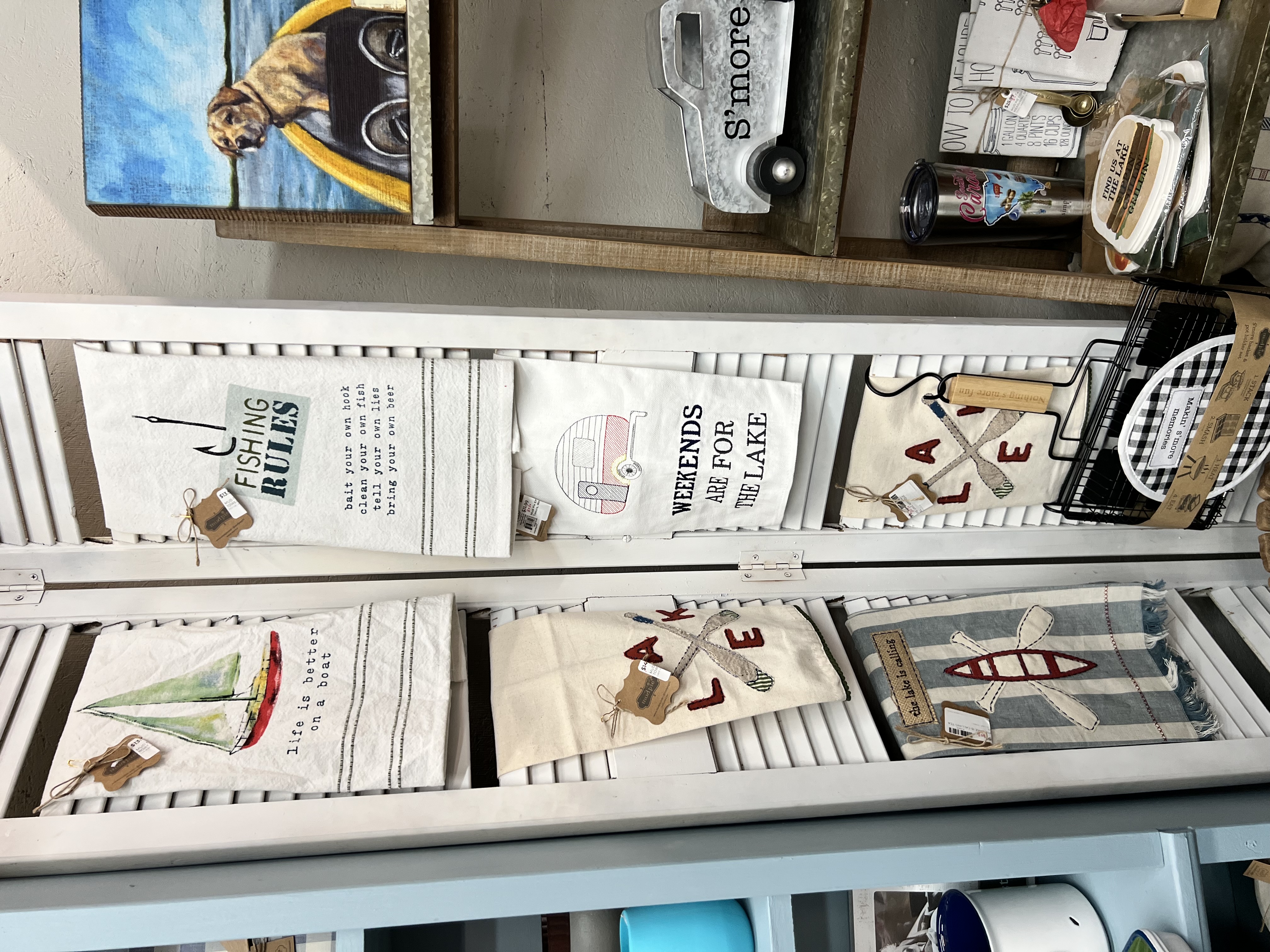 Smiling woman in a pink floral blouse standing in front of blooming trees.