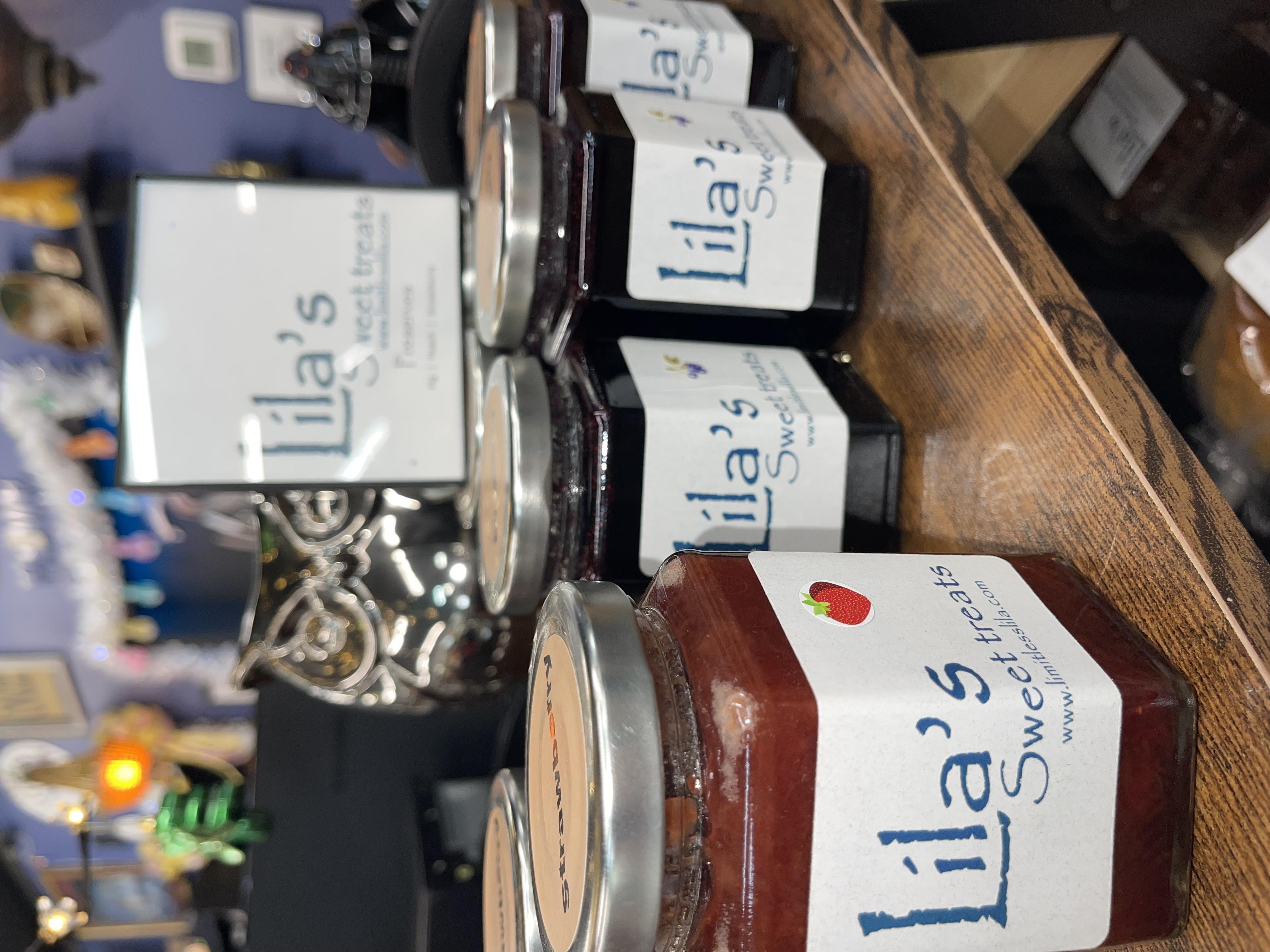 Vendor booth filled with vintage home decor, furniture, and accessories, including lamps, artwork, and dishes.