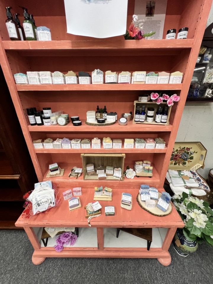 Display of colorful handmade soaps labeled with names like “Wine Country” and “Sweetness.”