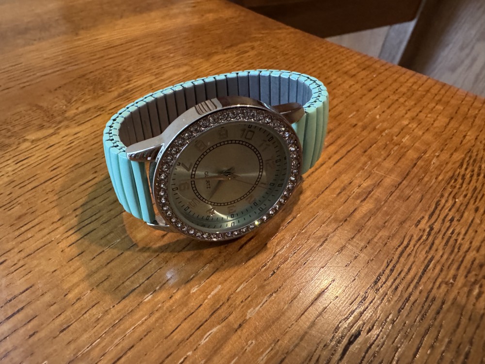 Stretch Turquoise Metal Band Watch with clear gemstone bezel.