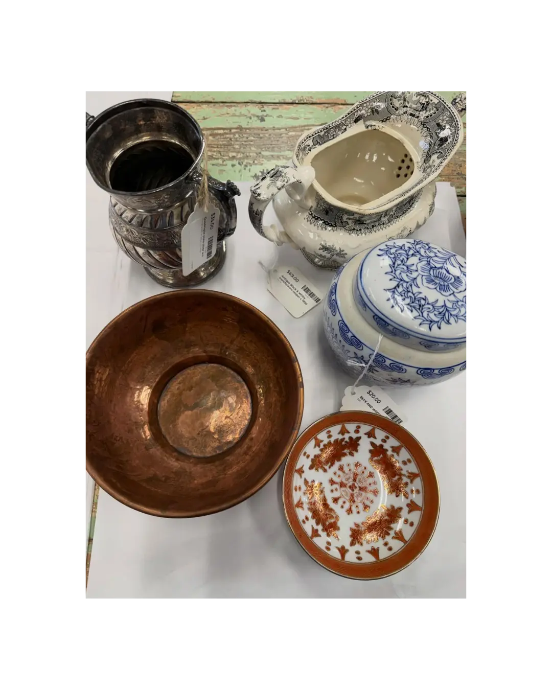 Vintage home décor including a silver pitcher, copper bowl, transferware teapot, and decorative ceramics.