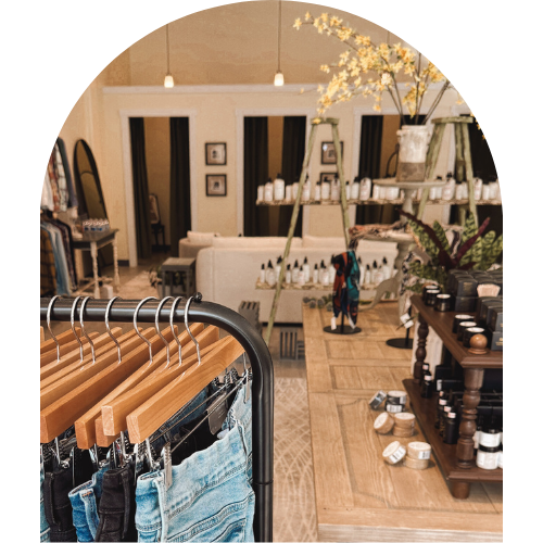 Denim clothing on hangers in the foreground with boutique displays and decor in the background.
