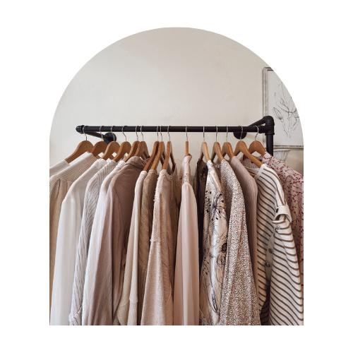 Neutral-toned clothing neatly displayed on a rack inside the boutique.