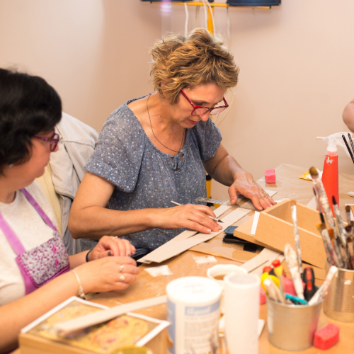 Two women enjoying a craft session at Simply Fetching Boutique, creating handmade items in a welcoming, creative space.