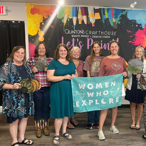 A group of women holding a sign that says women who explore.