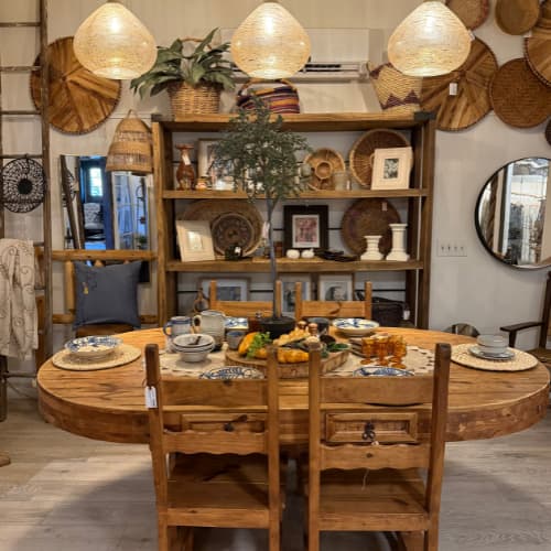 Wooden, rustic kitchen table with four chairs inside Under the Arbor store.