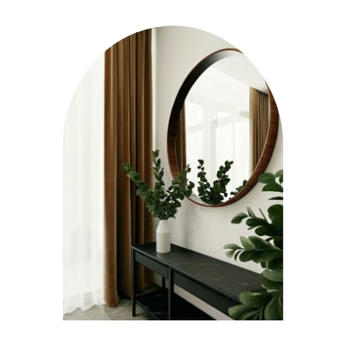 round brown mirror hung oevr a black entryway table.