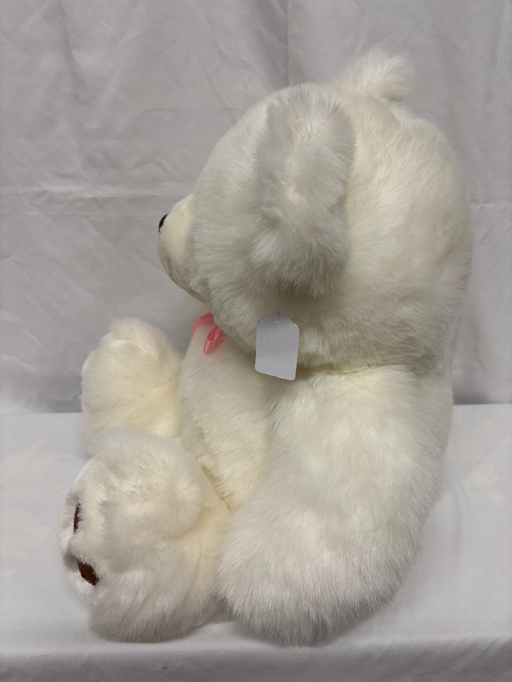 Plush big white teddy bear with a pink satin bow brown pads