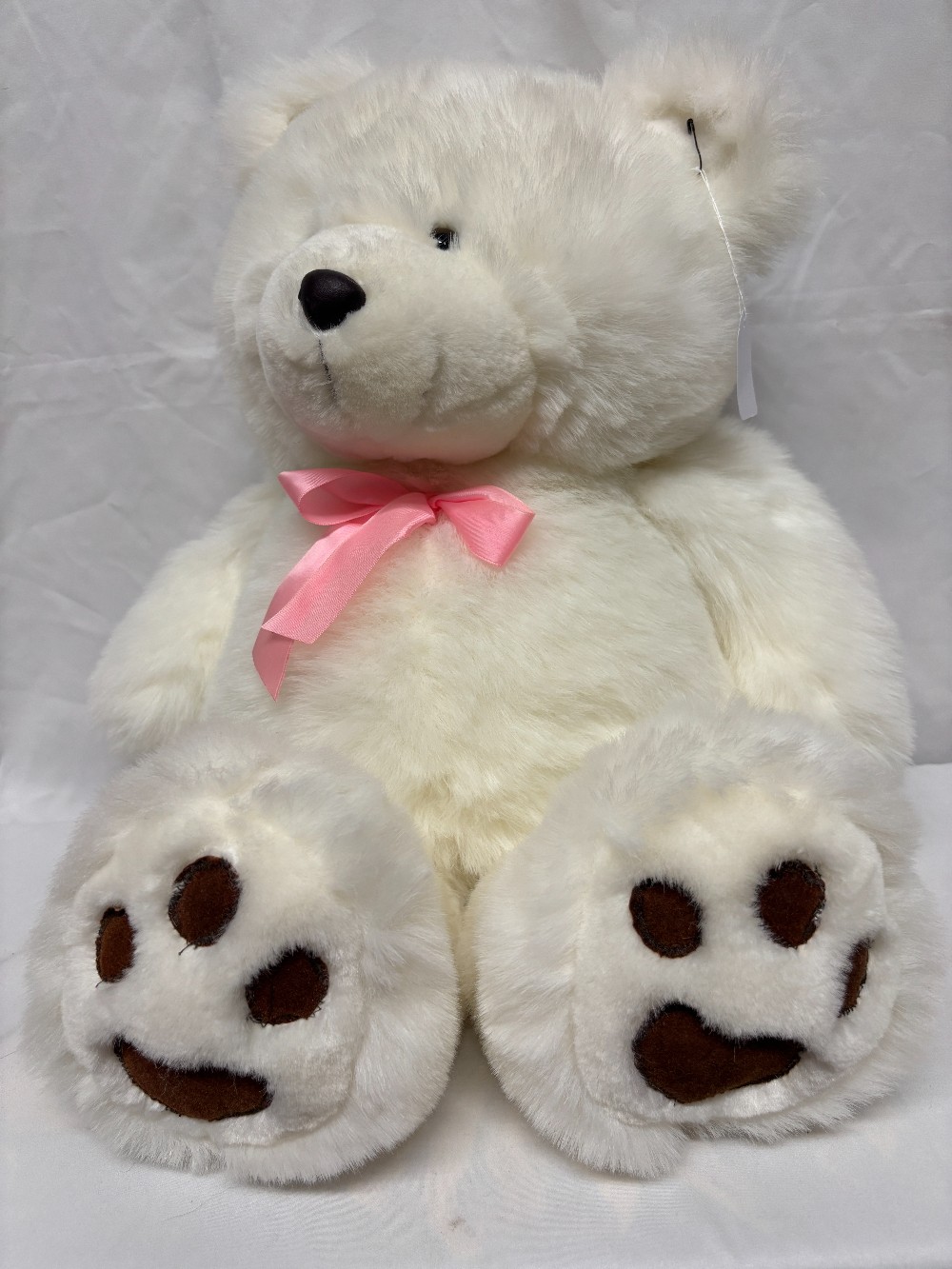 Plush big white teddy bear with a pink satin bow brown pads