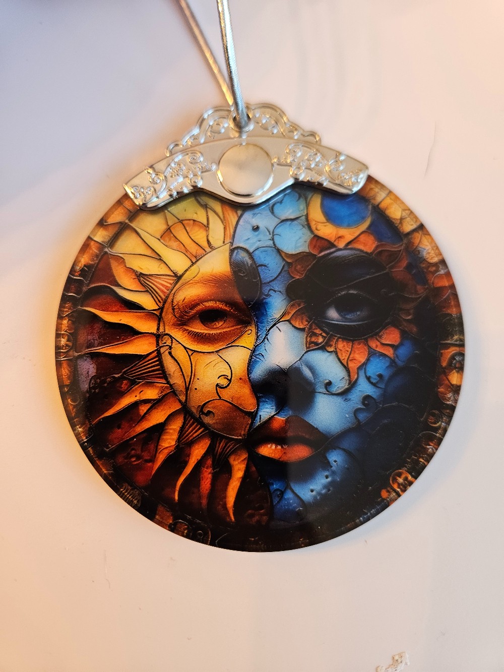 This Jocidea stained glass suncatcher ornament features a vibrant sun and moon celestial design
