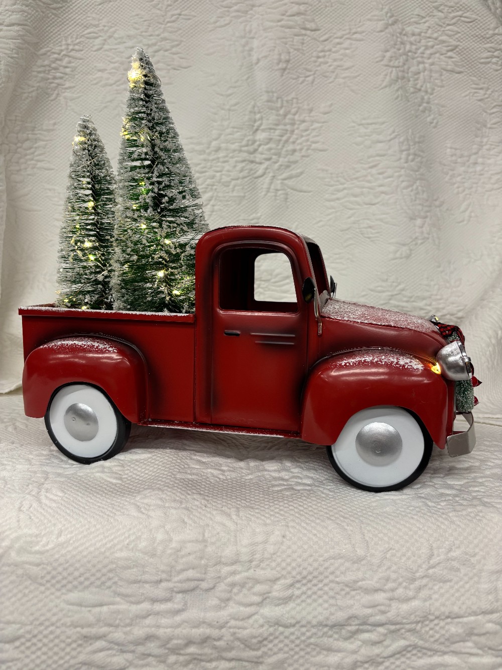 Red metal pick up w/two lighted evergreens & headlights