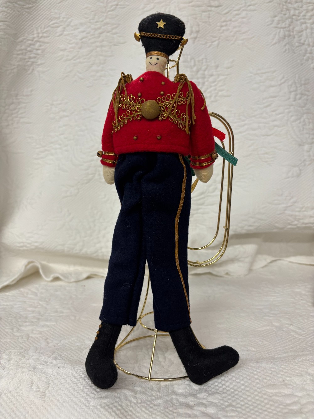Felt toy soldier attached to brass wire trumpet