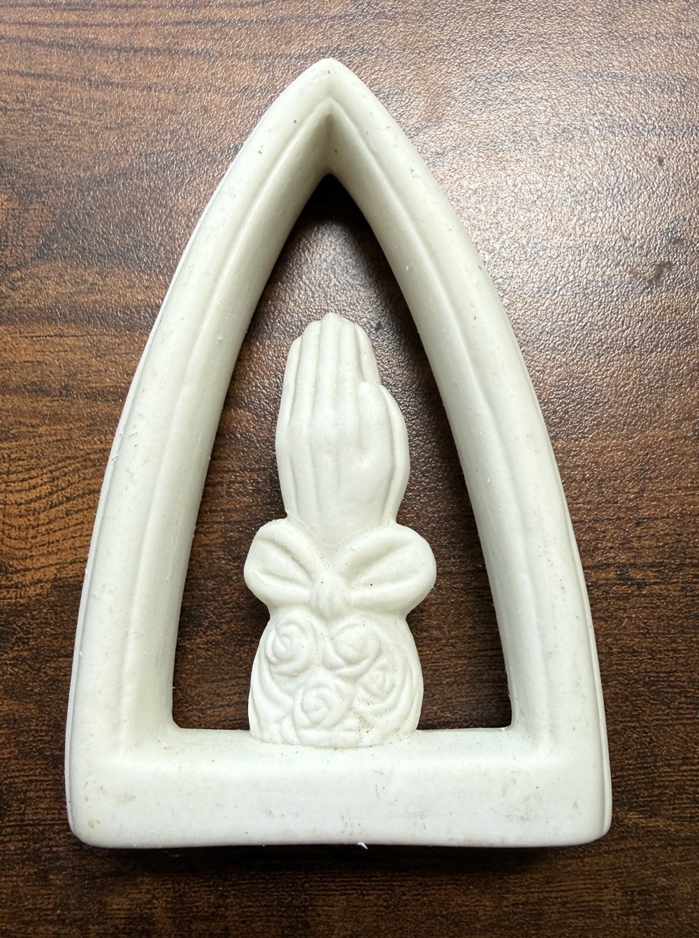 Ceramic prayer hands in frame