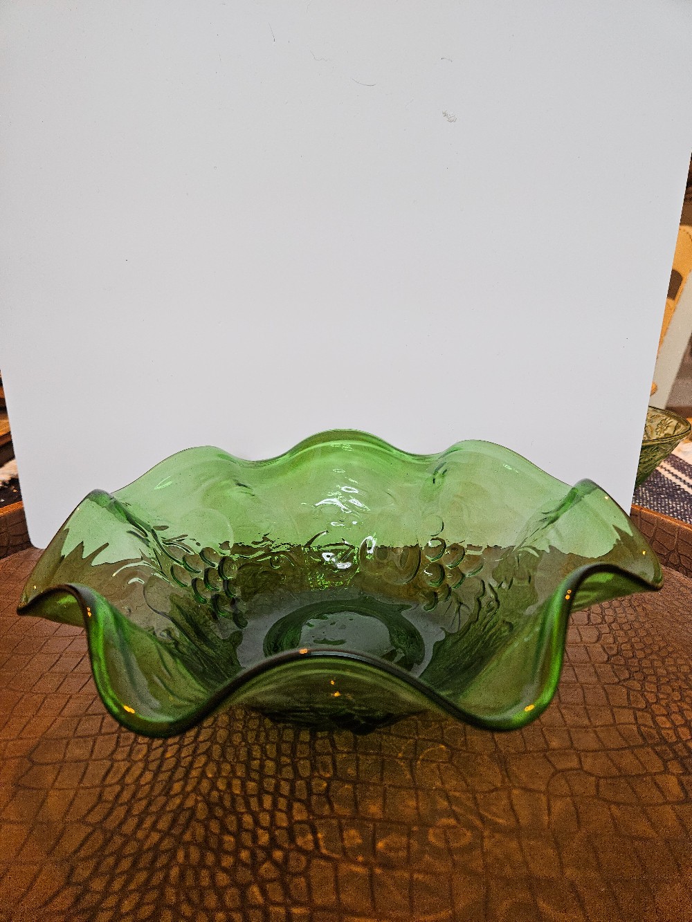 Vintage green glass bowl with a ruffled edge,