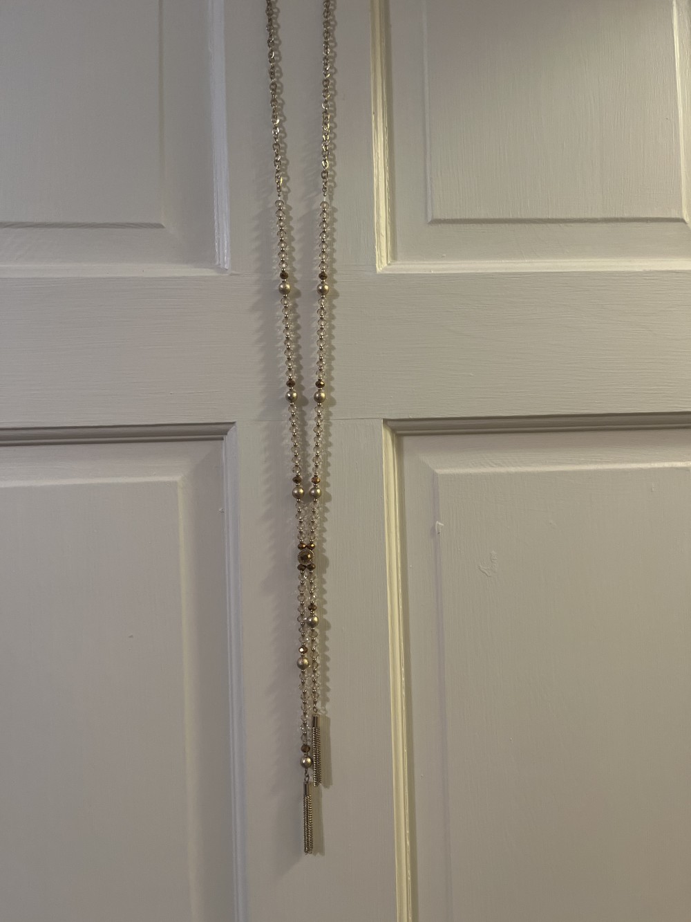 This pendant necklace features a unique, irregularly shaped stone resembling a white marble or howlite centerpiece.