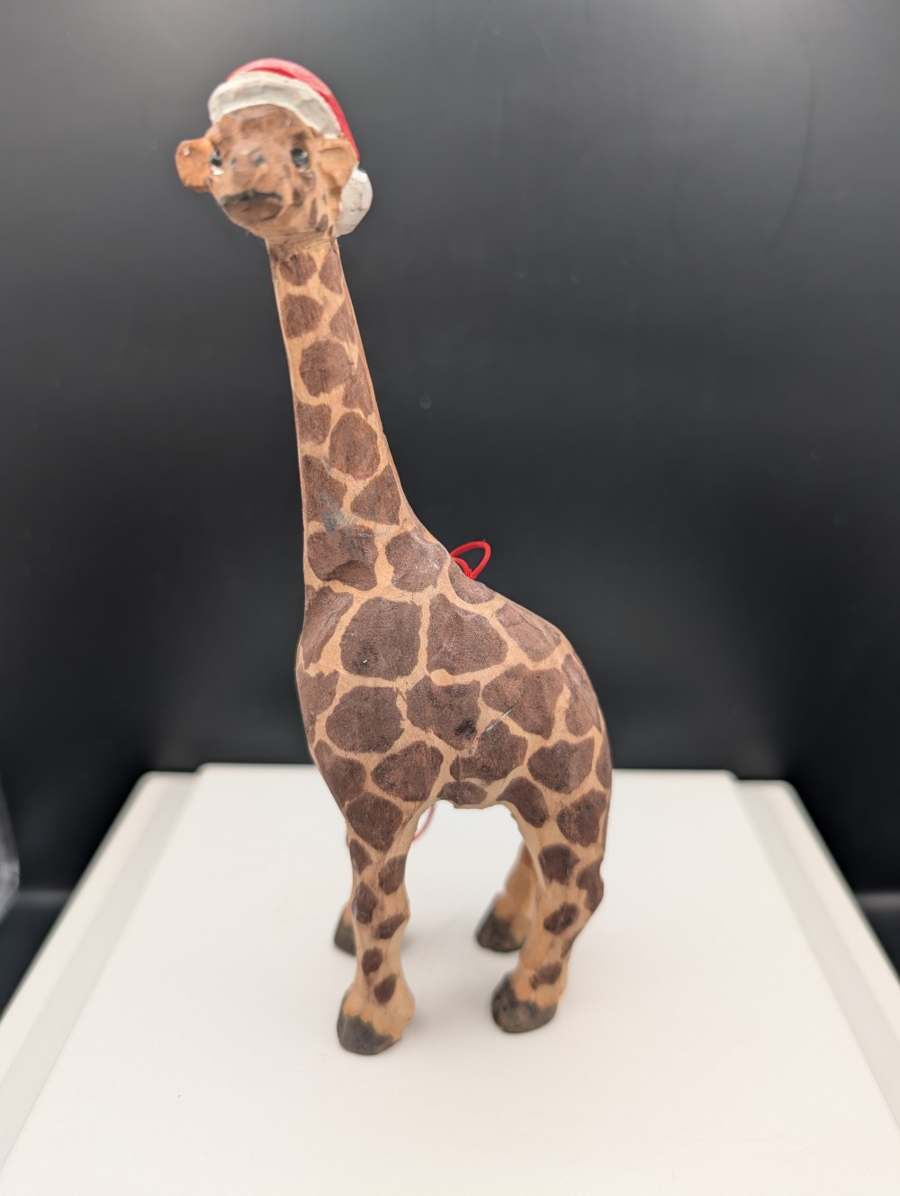 Carved wooden giraffe with Santa hat