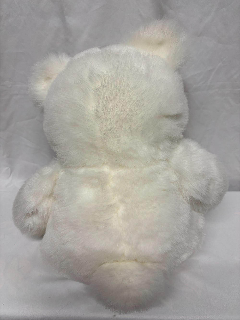 Plush big white teddy bear with a pink satin bow brown pads