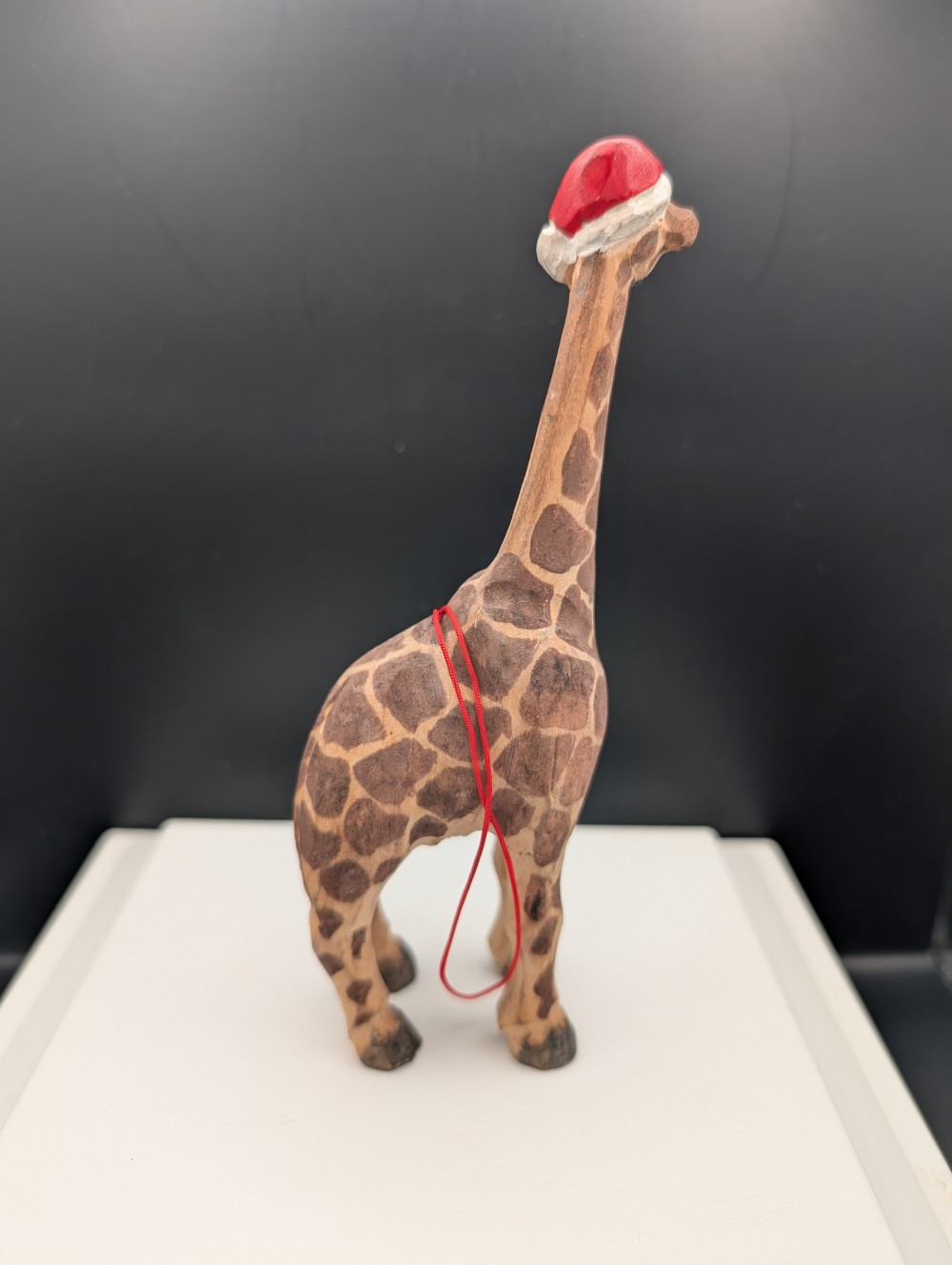 Carved wooden giraffe with Santa hat