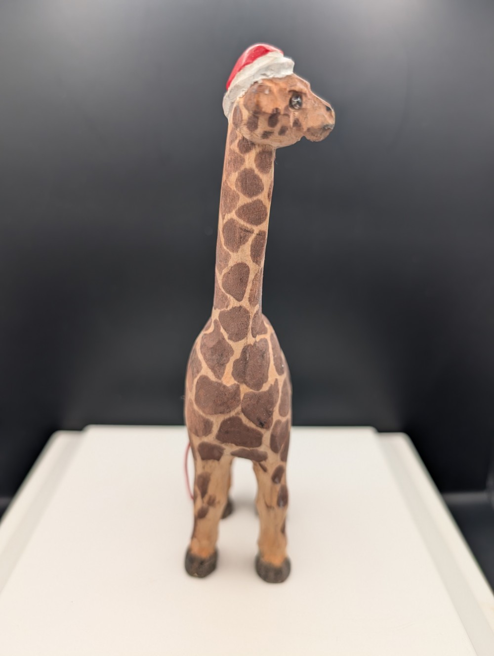 Carved wooden giraffe with Santa hat