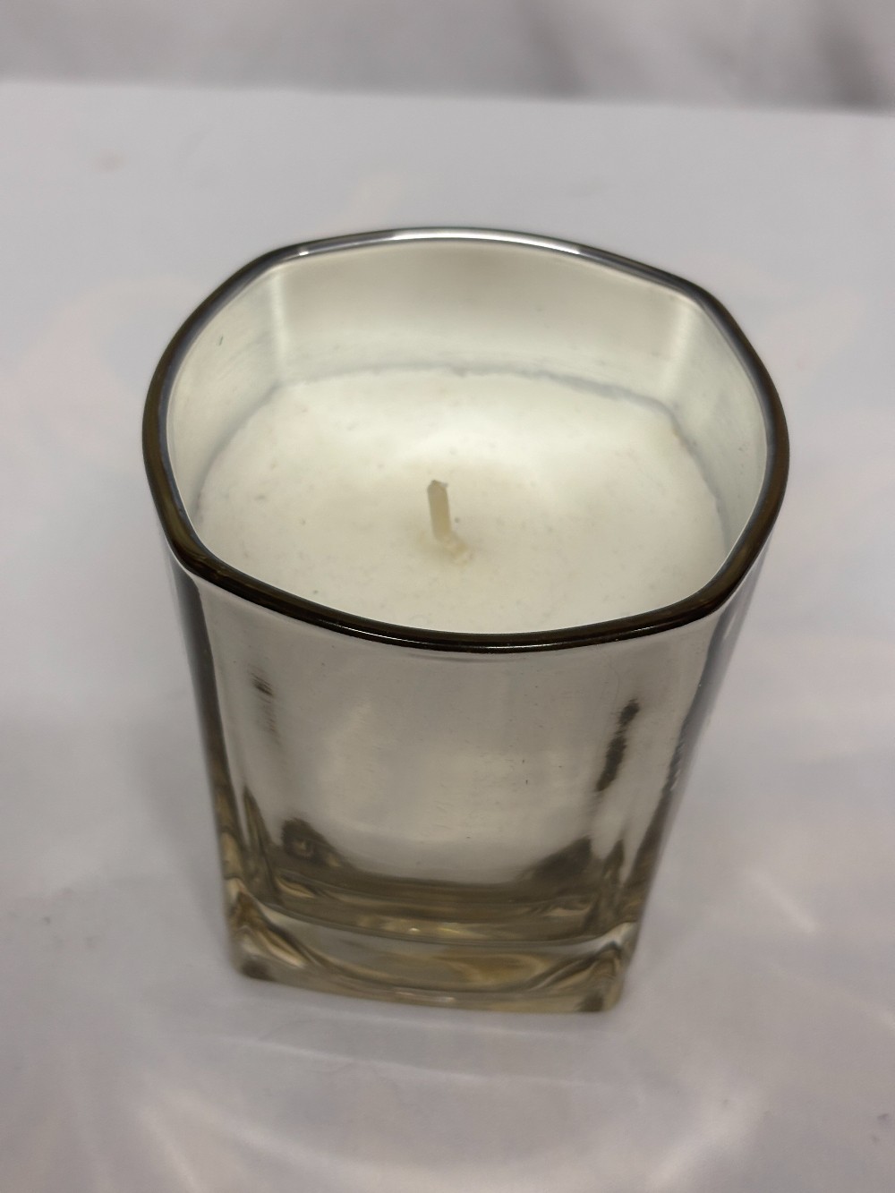 Candle off white smells good in a silver mirror glass.