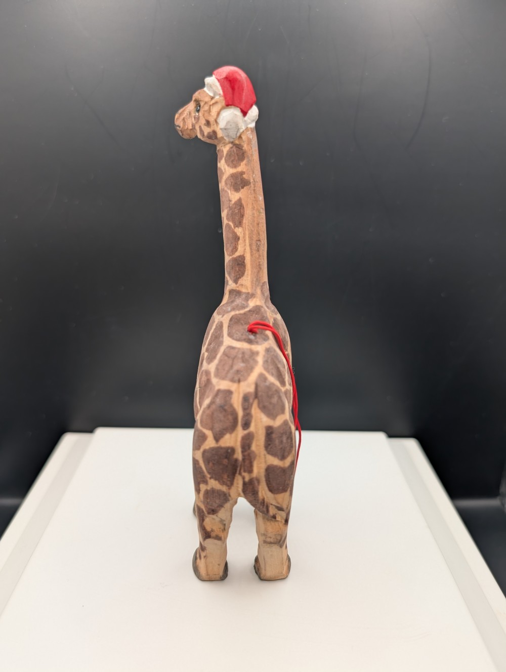Carved wooden giraffe with Santa hat