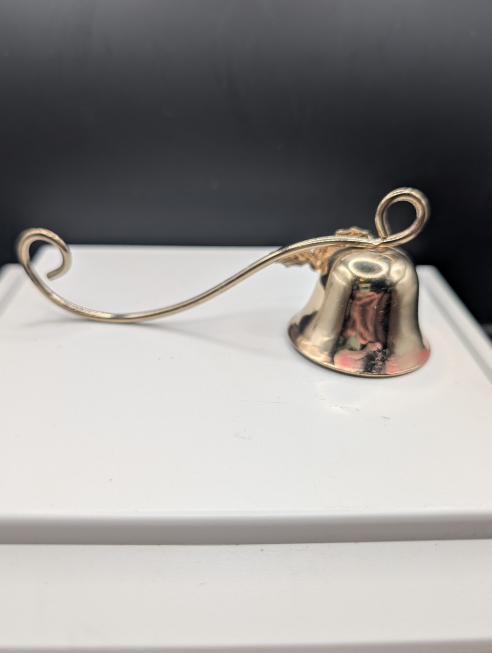 Metal candle snuffer with holly leaves