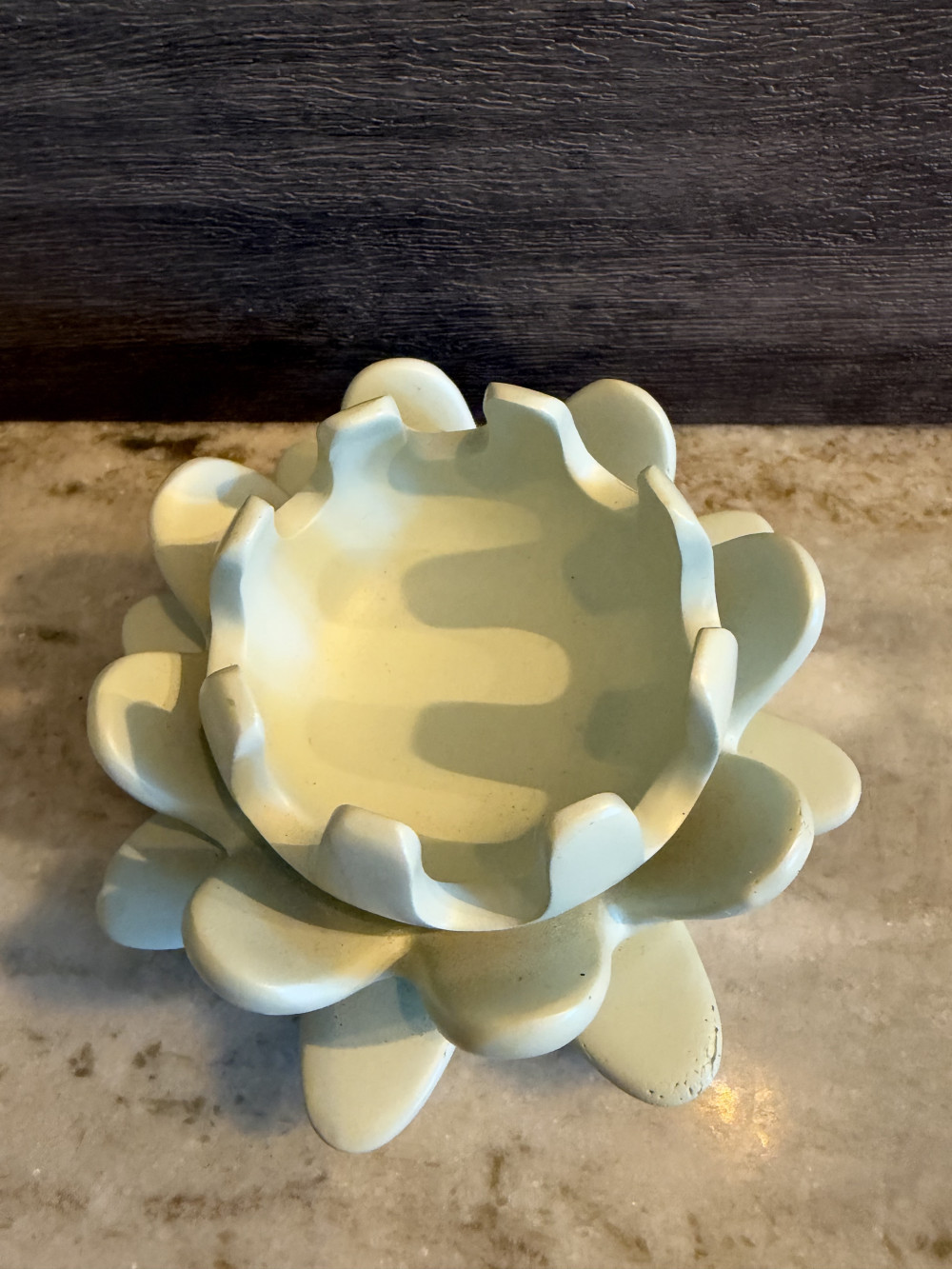 a light green ceramic lotus flower candle holder.