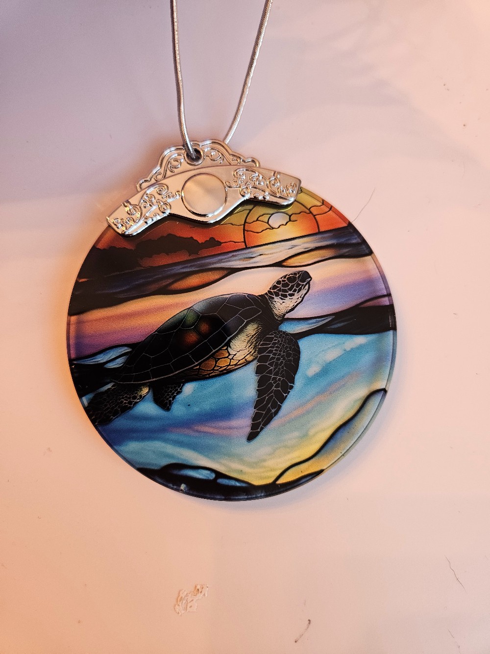 This Jocidea ornament features a colorful, stained glass sea turtle design