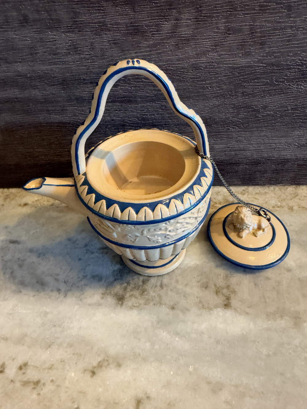 a vintage Nini hand-painted miniature caneware teapot (model #6-17), featuring a tan and blue color scheme, a lion finial on the lid, and an attached chain detail.
