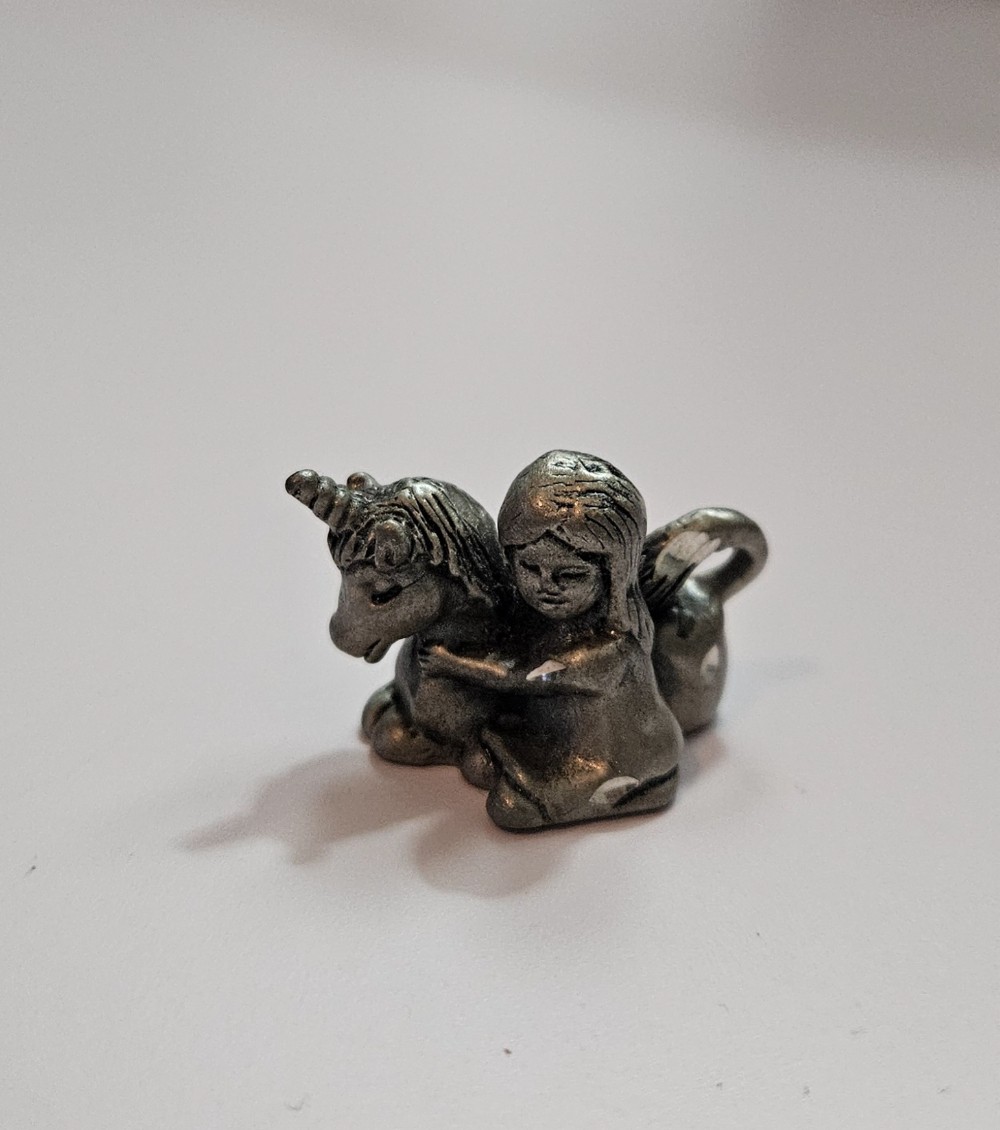 vintage miniature pewter figurine of a little girl hugging a baby unicorn,