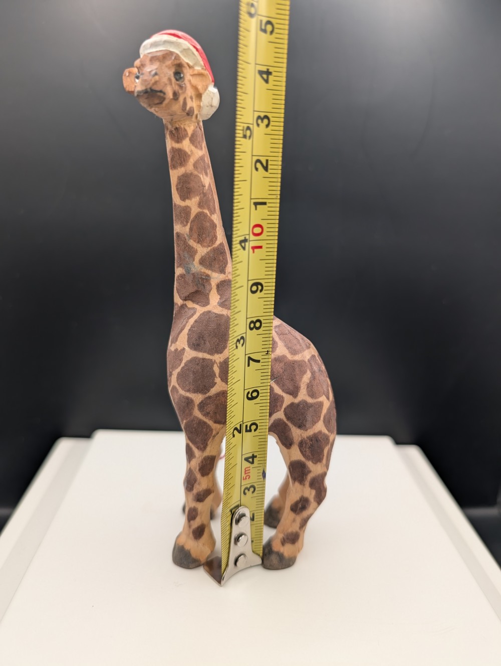Carved wooden giraffe with Santa hat