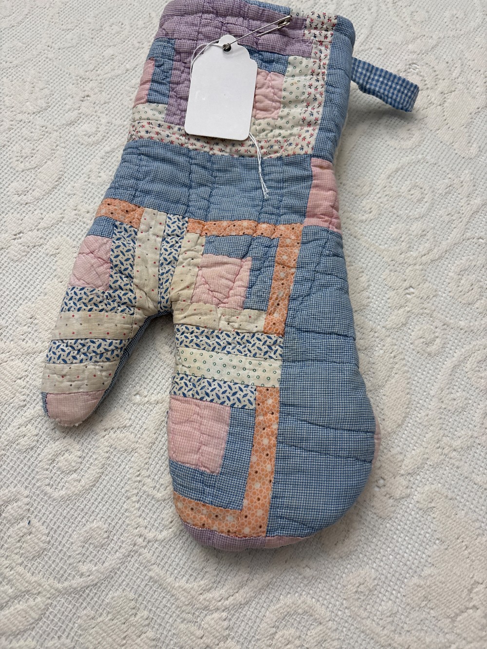 a cutter quilt oven mitt that is pink and blue