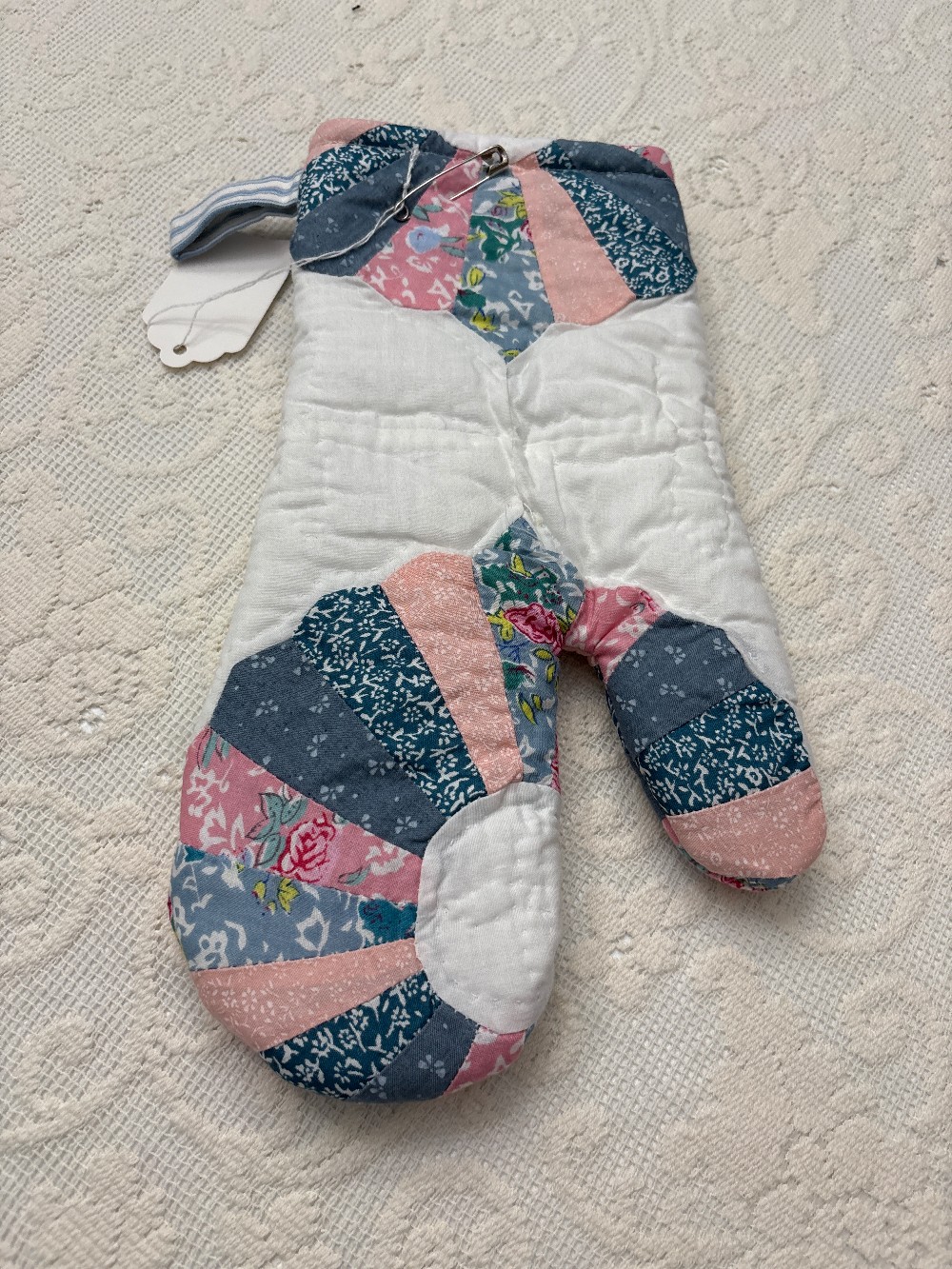 a cutter quilt oven mitt that is pink and blue