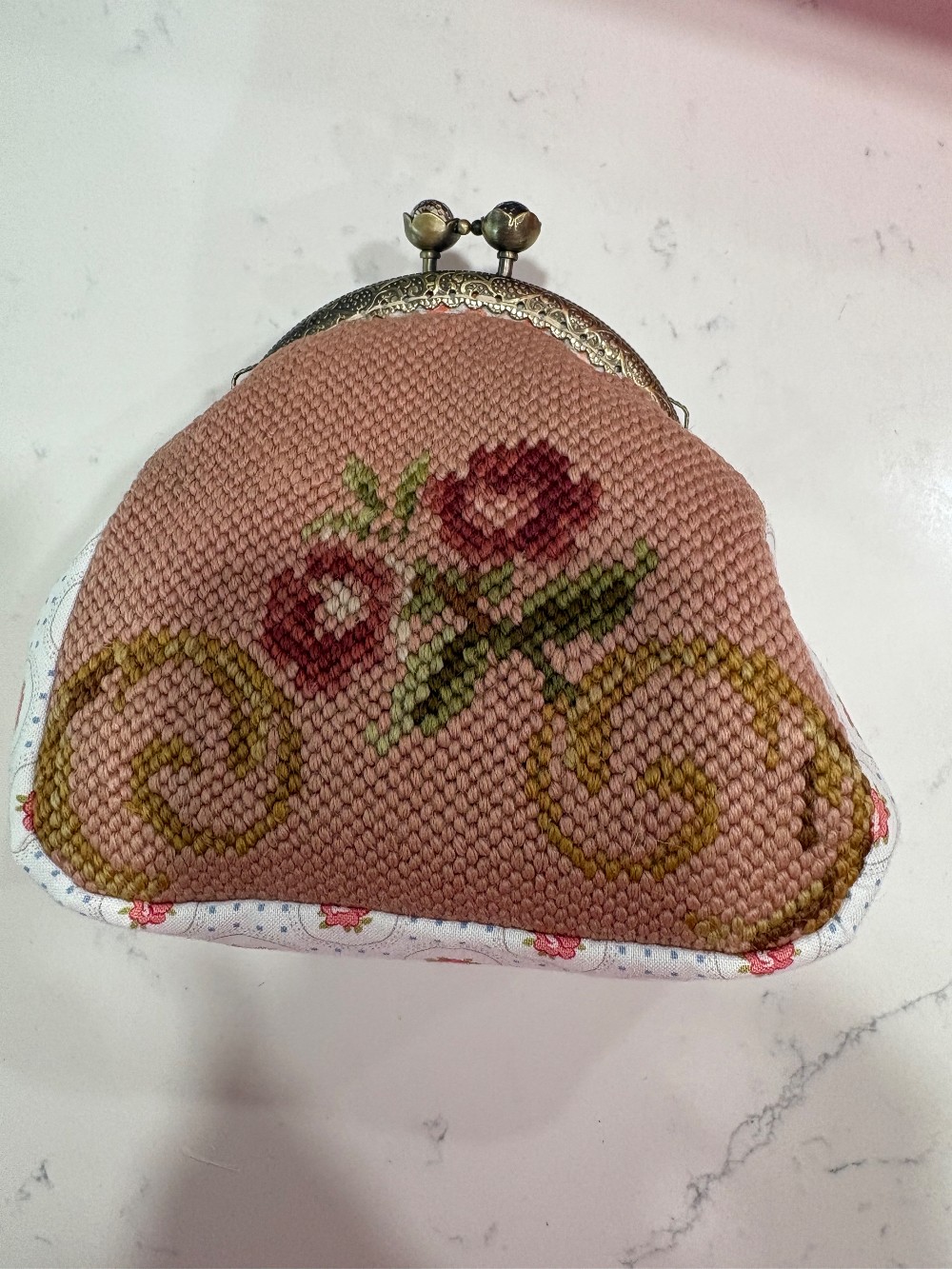 A beige and rose coin purse made from vintage needle point