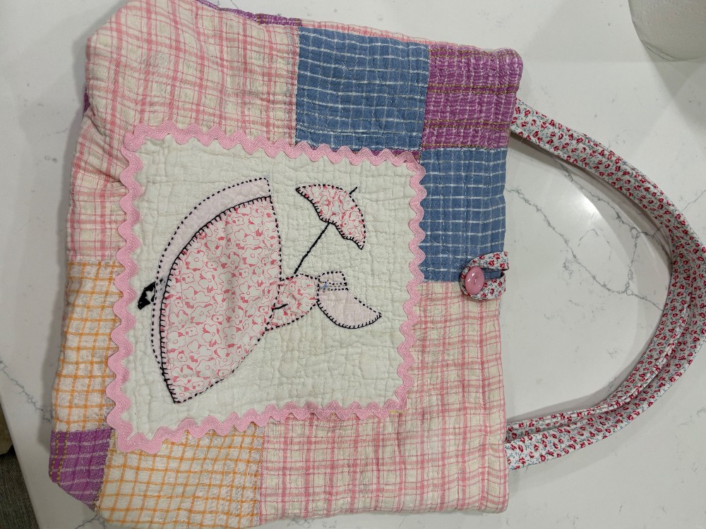 Tote bag made from a cutter quilt with a quilt square featuring a girl with an umbrella