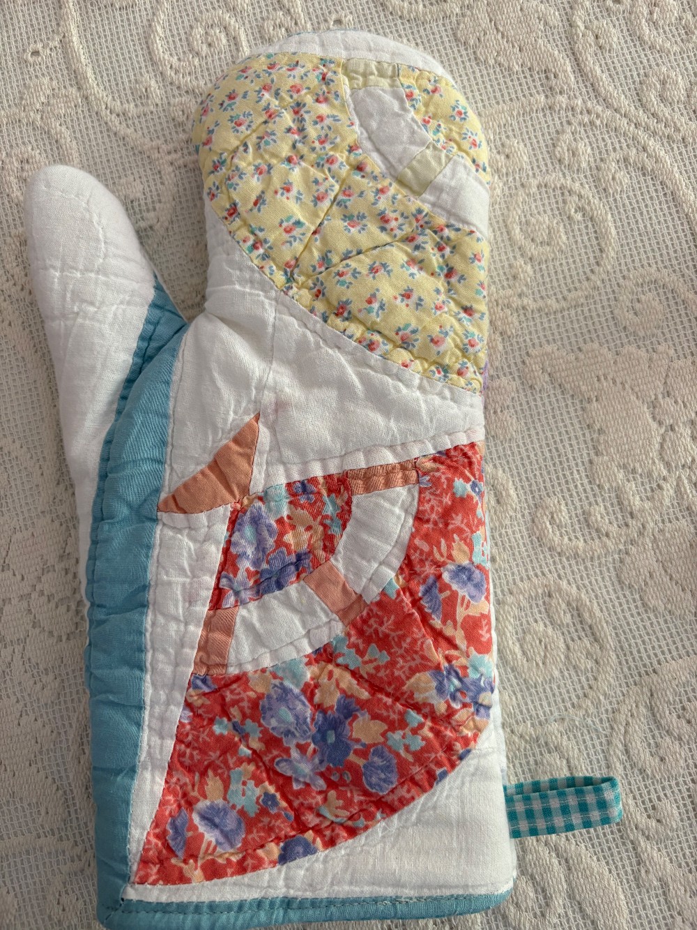 a cutter quilt oven mitt that is pink and blue