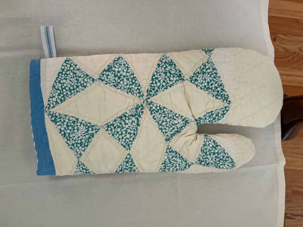 a cutter quilt oven mitt that is pink and blue