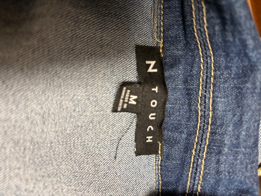 A jean jacket in size medium with a quilt did appliqué on the back