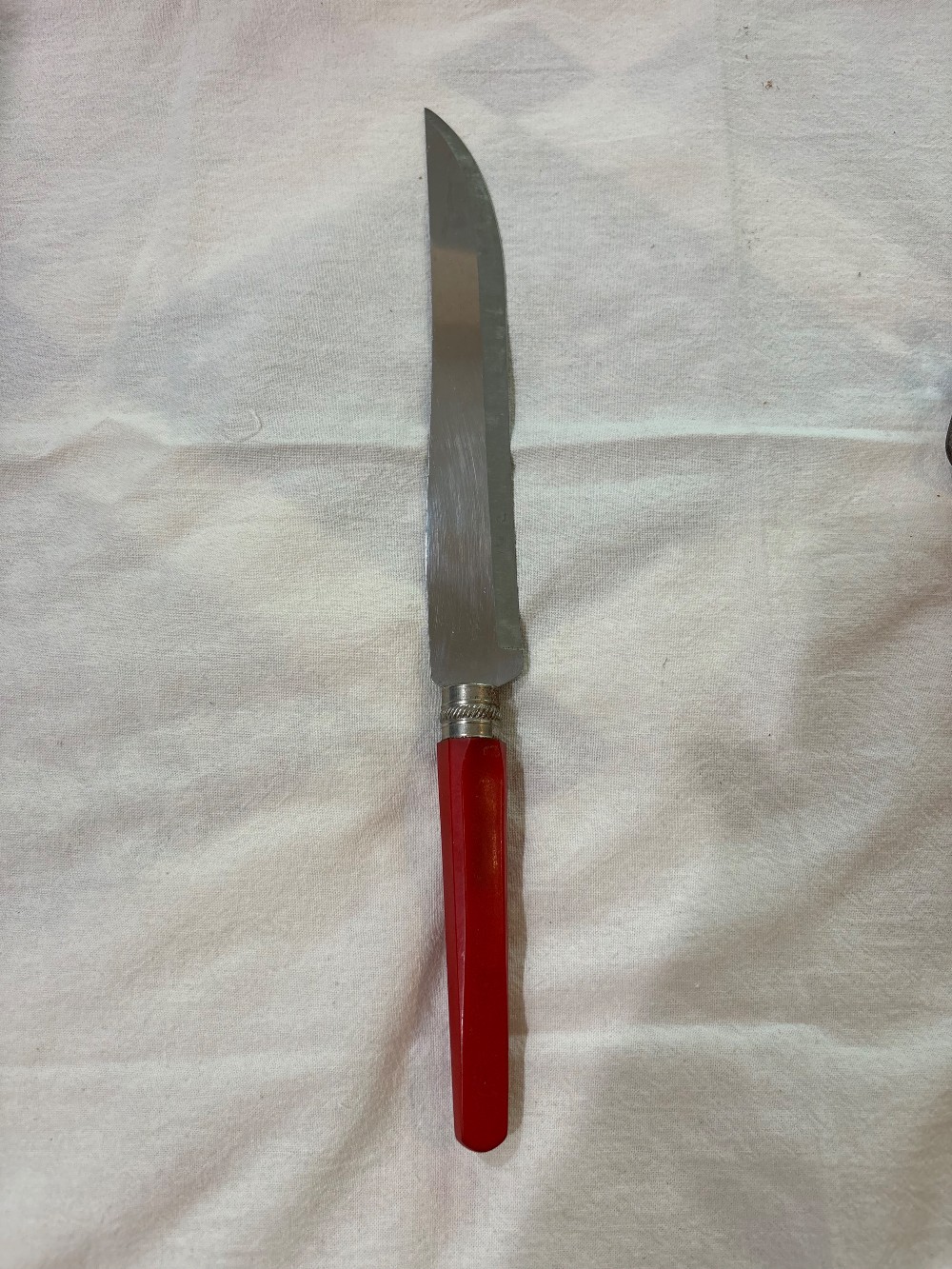 A RED BAKELITE HANDLE CARVING SET.