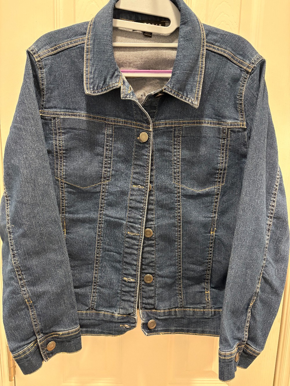A jean jacket in size medium with a quilt did appliqué on the back