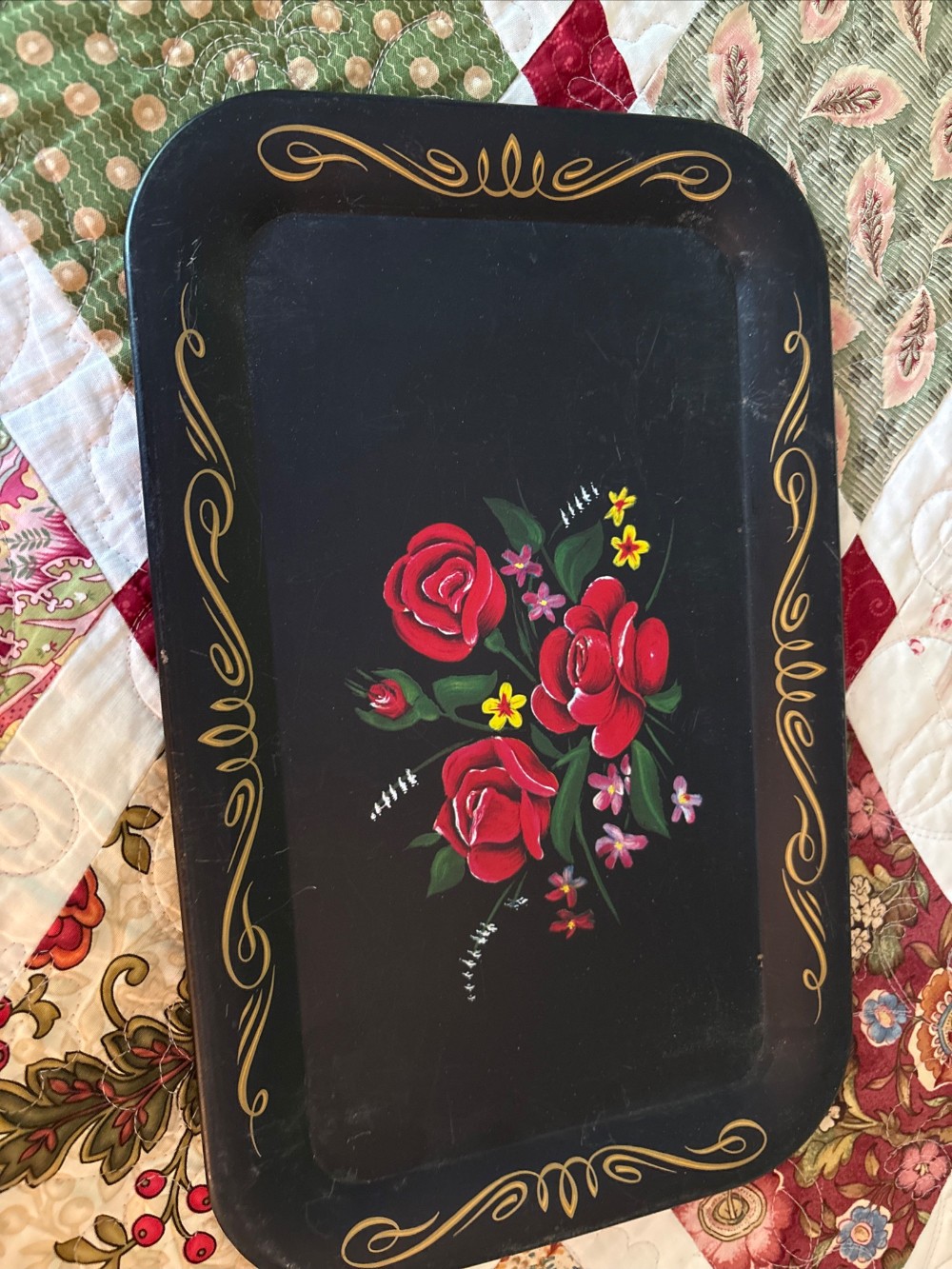 A black vintage metal try with red roses