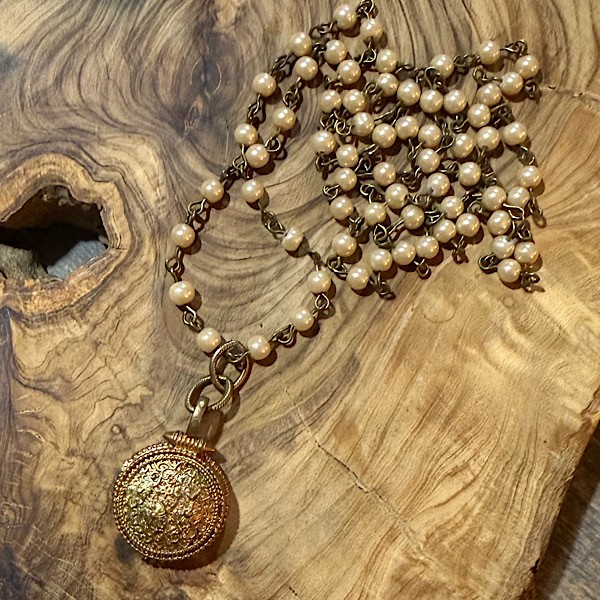 Vintage vibe locket w/copper toned patina on long chain of petite linked champagne glass pearls.  Approx  30