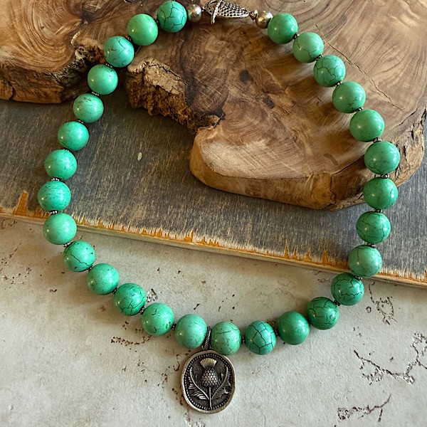 Beaded short necklace in turq green w/thistle pewter tone pendant