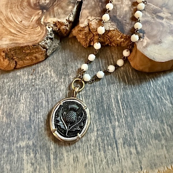 Thistle pendant in G/S finish on short white opaque linked beads